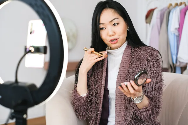 Beauty vlogger demonstrating makeup tips using a ring light during live stream. When to build a beauty creator partnerships ninety day plan