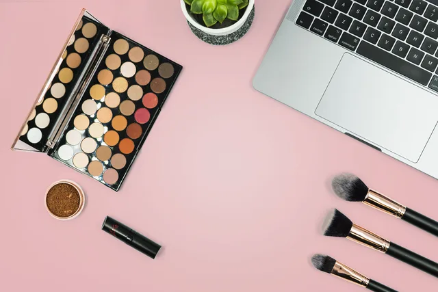 This photo shows a range of make up and make up brushes on a pink background next to a laptop as a beauty blogger gets ready to update her make up blog. We took this image during our own shoot, but have now decided we'd like to share it by releasing it under Creative Commons. Please feel free to use. Beauty creator partnerships survey tools explained