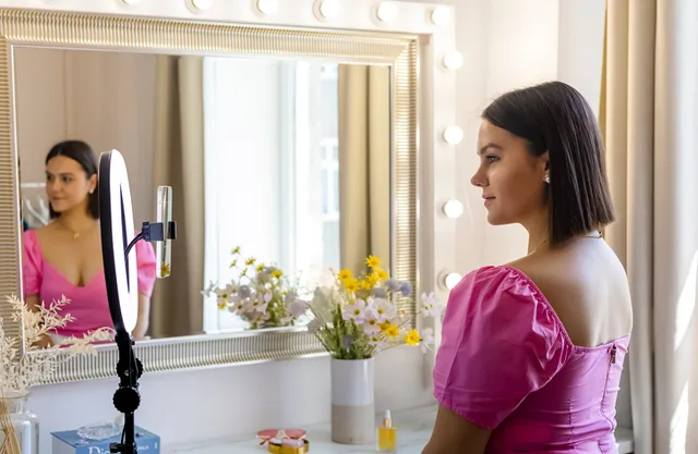 A young woman records a vlog using a ring light in front of a stylish mirror. Beauty influencers and HMRC: gifted products, affiliate income, the £1,000 trading allowance and VAT barter
